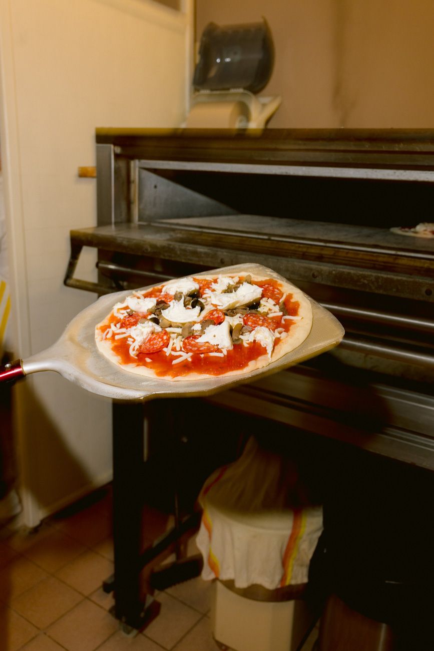 Guests making pizza during a welcome party by the shores of Lake Garda. Planned by Solidea Events
