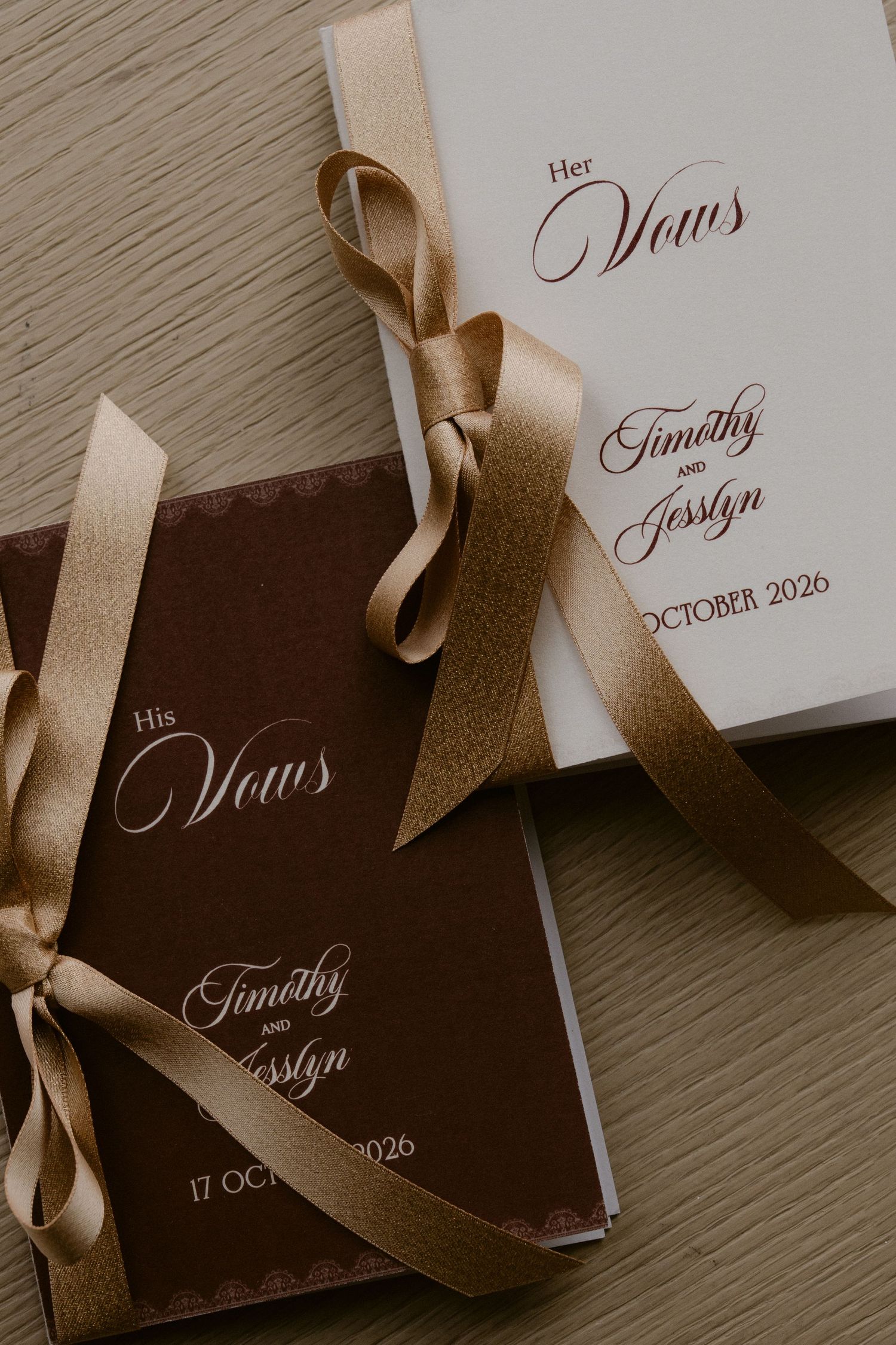 His and Her wedding vow booklets tied with gold ribbons, personalized for Timothy and Jesslyn, October 2026.