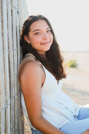 Relaxed portraits against weathered wooden posts in casual summer clothing.