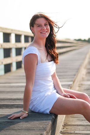 A casual outdoor portrait on a wooden boardwalk during golden hour.
