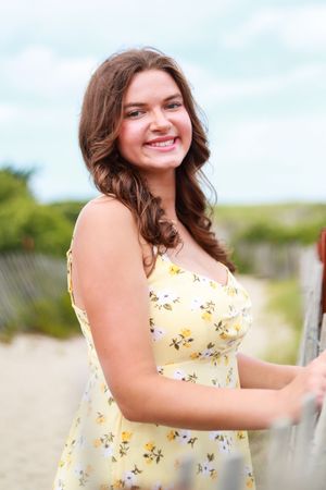 Outdoor photos in a sunny field wearing a light yellow floral dress.