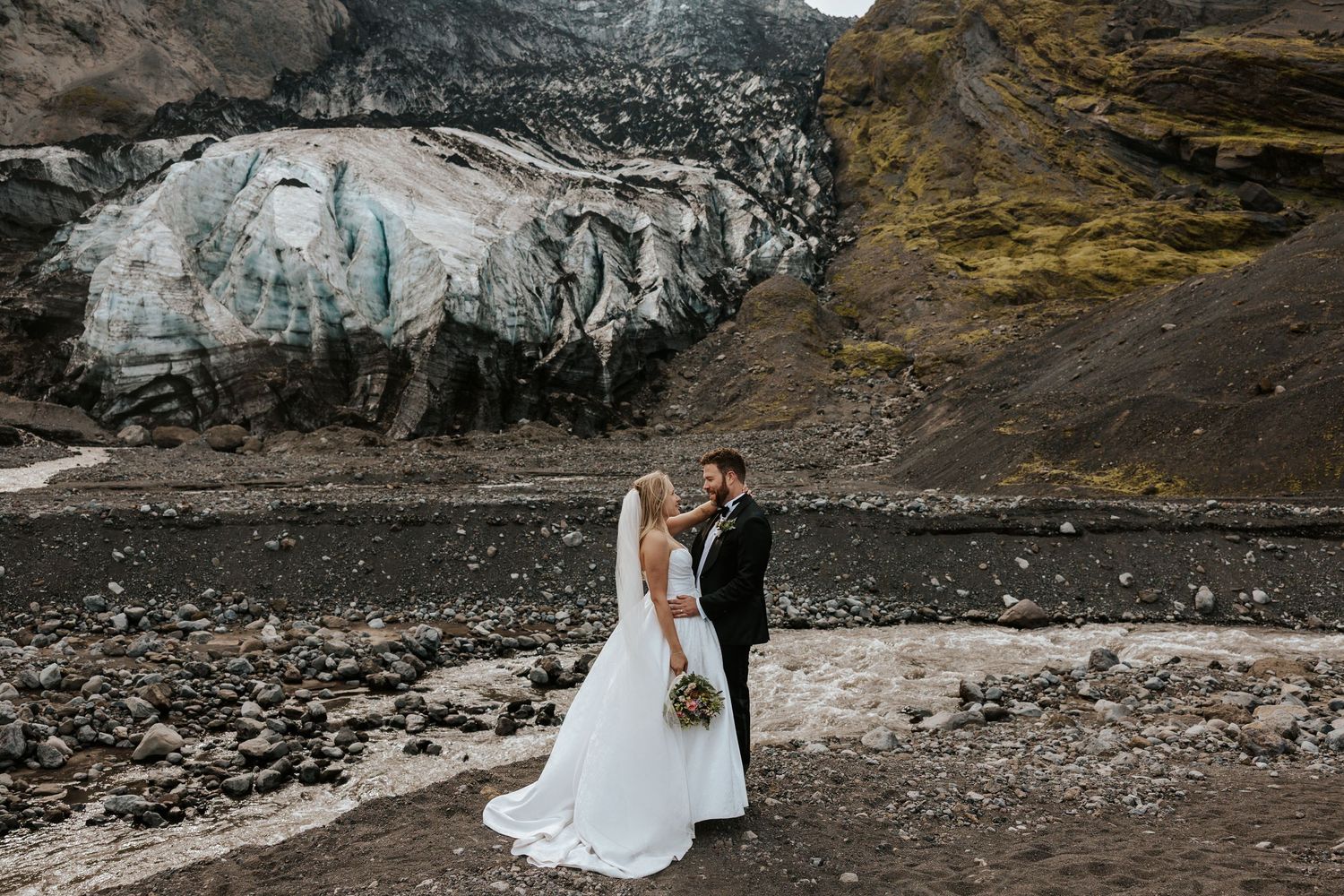 bride and groom staring into each other's eyes at Thórsmörk with glacier and mountain behind them