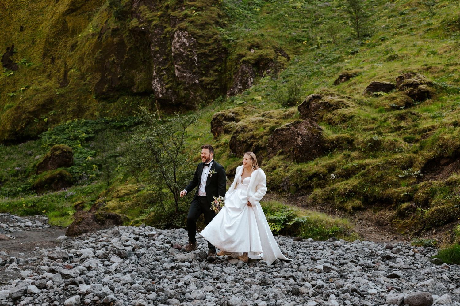 bride and groom walking hand in hand in canyon in Thórsmörk, iceland
