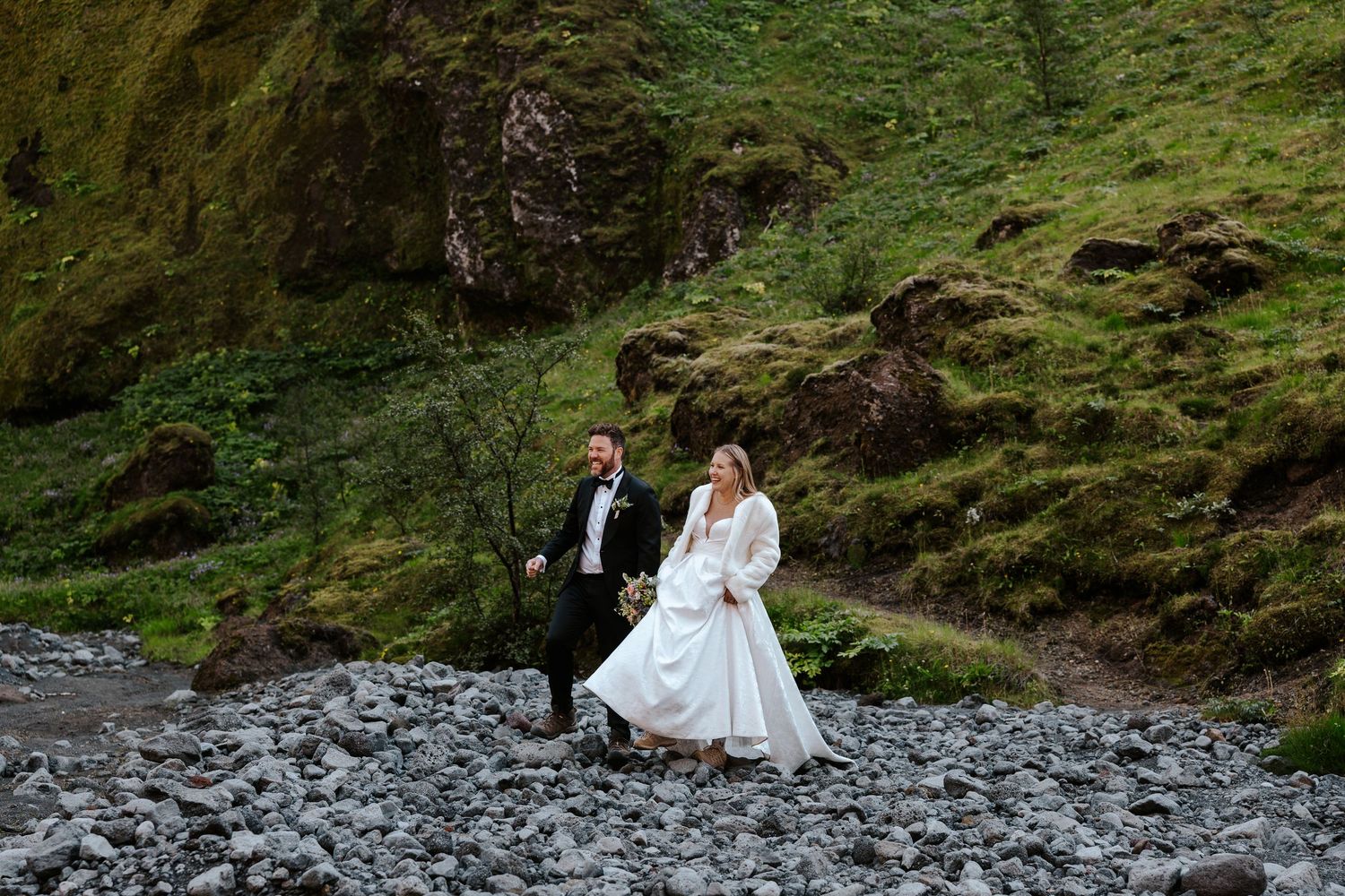 bride and groom walking hand in hand in canyon in Thórsmörk, iceland