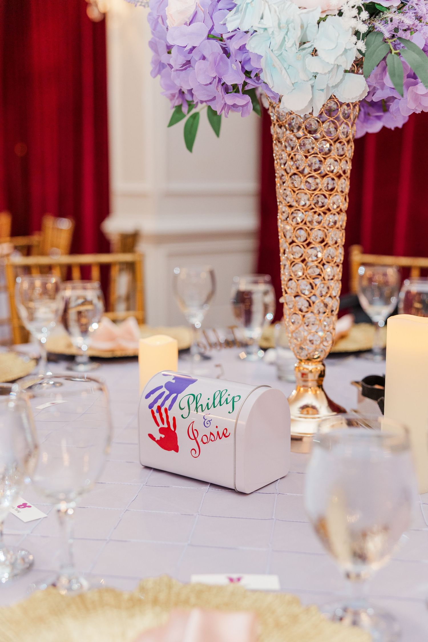 Elegant wedding reception table with gold vase, purple hydrangeas, and personalized Phillip & Josie favor box.