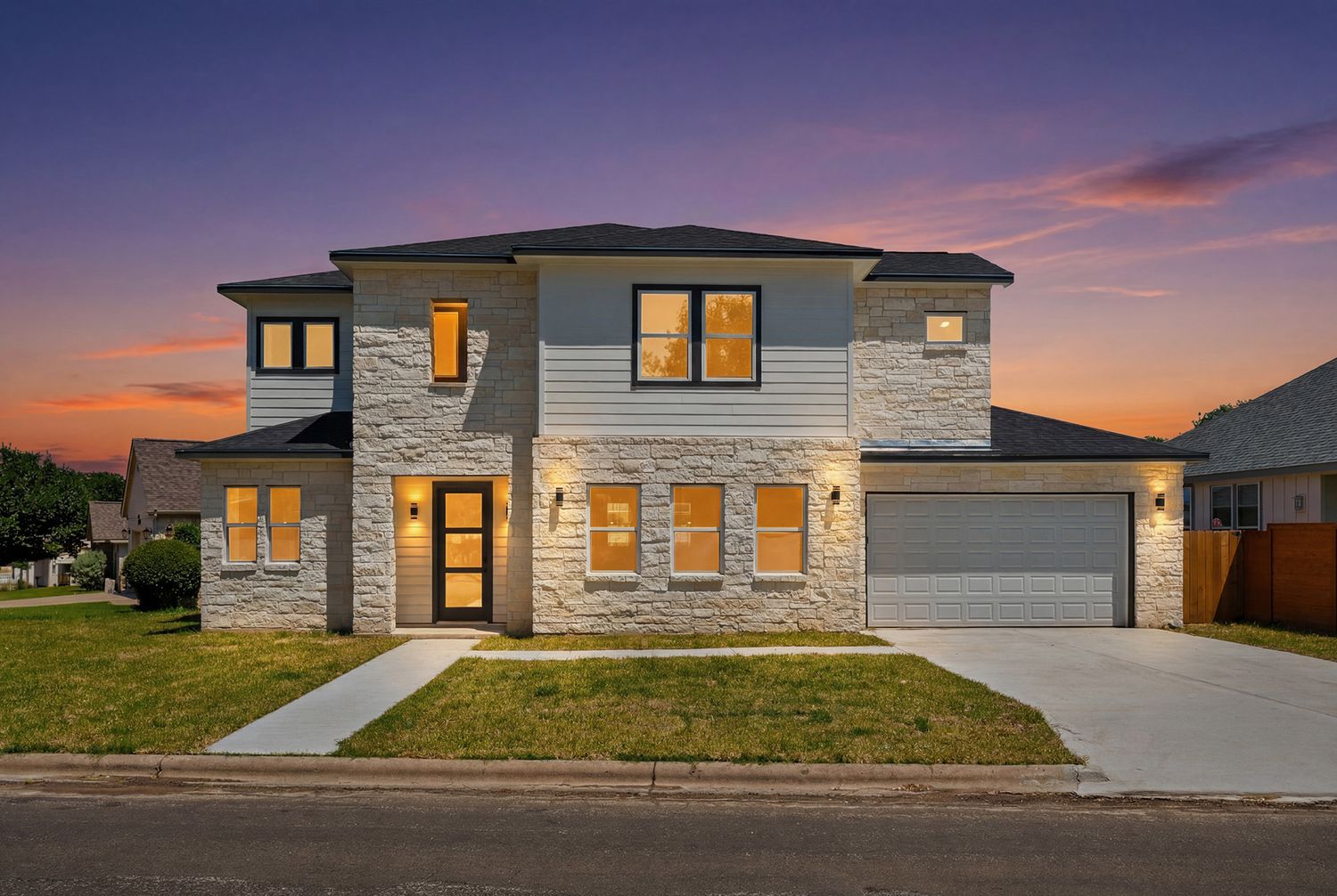 Two-story brick and siding home with attached garage and virtual twilight, with a manicured front lawn and concrete driveway.