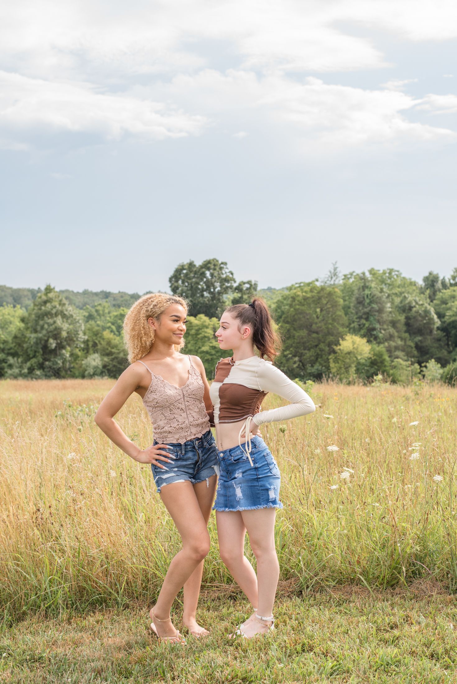 teen siblings exchanging a glance and starting to smile during a family photo session in northern Virginia