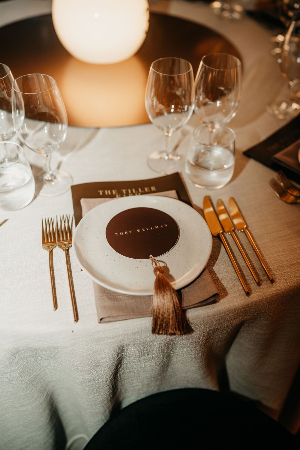 Elegant place setting at The Tiller restaurant with gold cutlery and personalized menu card.