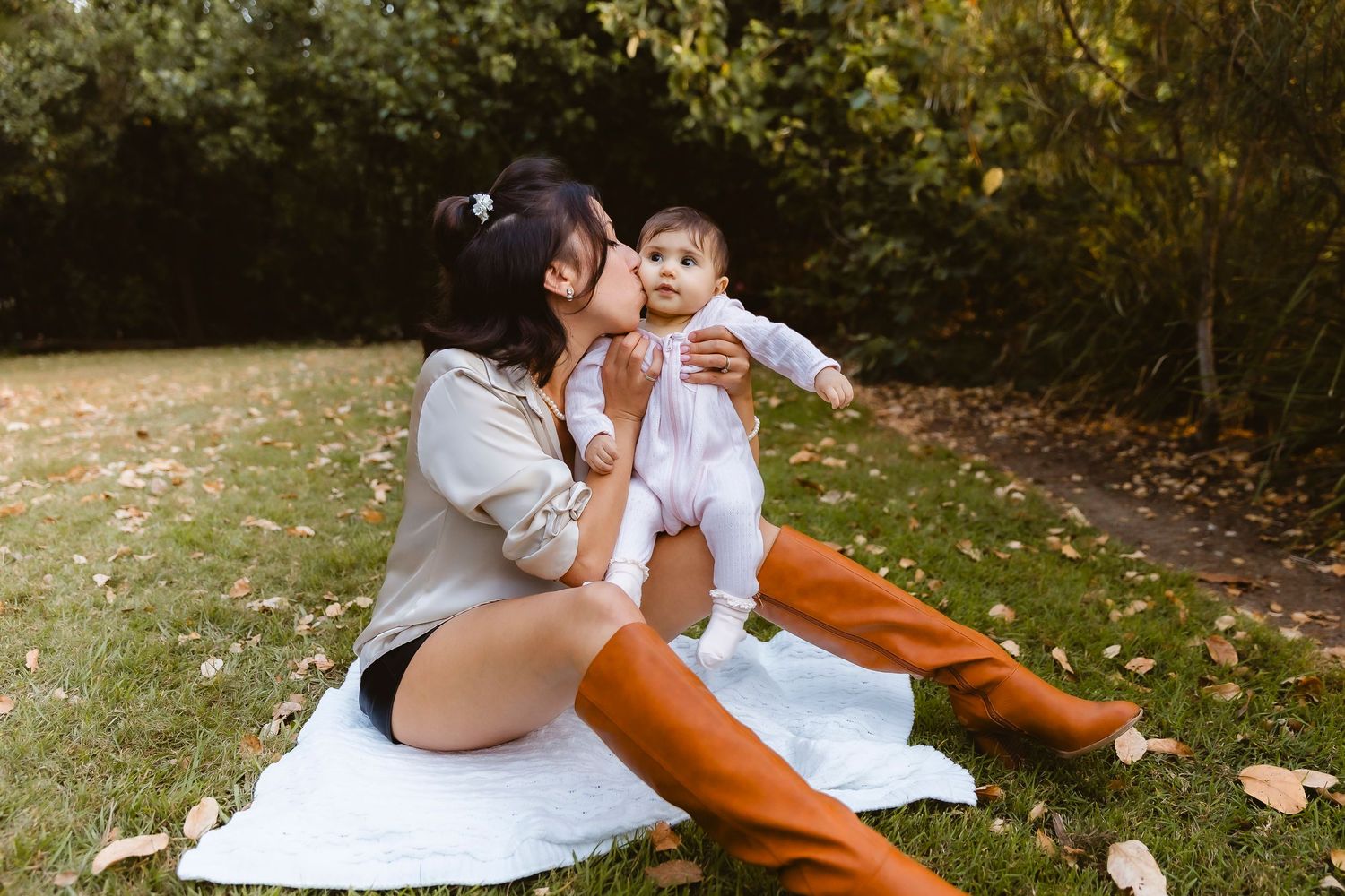 Mum in flower patterned dress holding baby in forest during family photo shoot