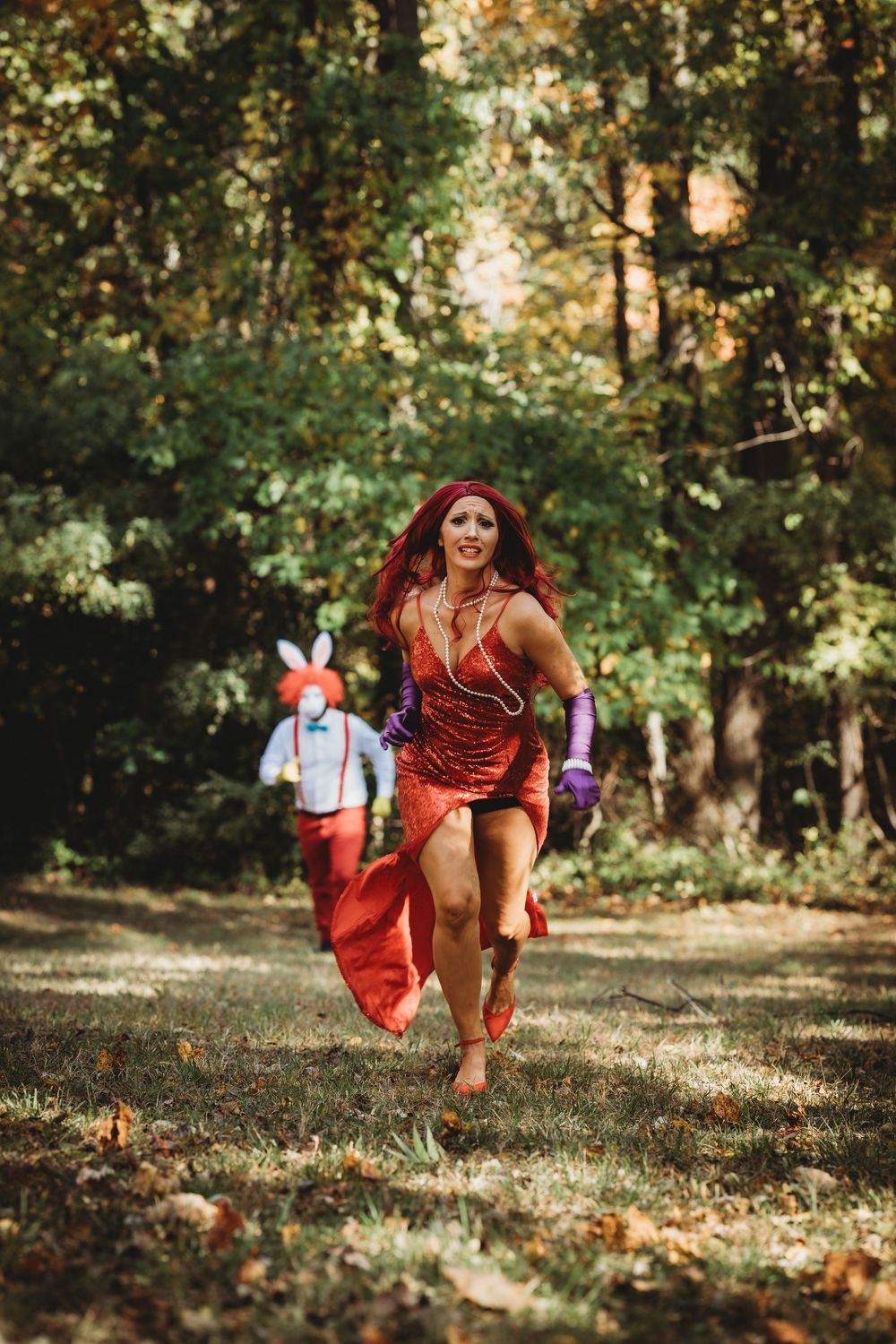 A person in a flowing red dress performs a graceful levitating pose in a sunlit autumn forest setting.
