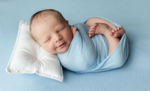 Newborn boy in a light blue wrap on a white pillow. Greenville, SC newborn photographer, Easley, SC Newborn photographer