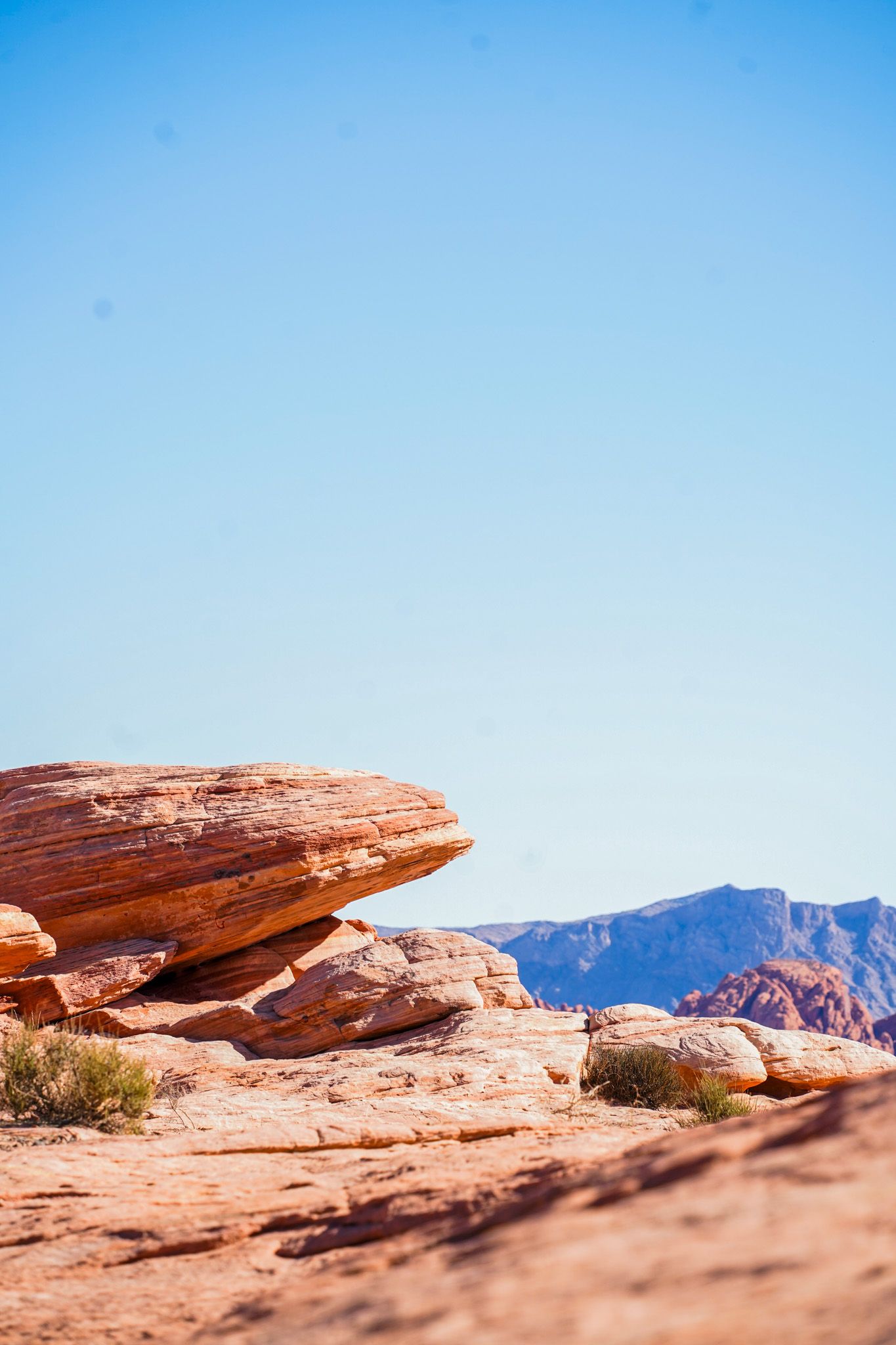 Red rock formations and desert landscape against blue sky in Valley of Fire State Park, Nevada.