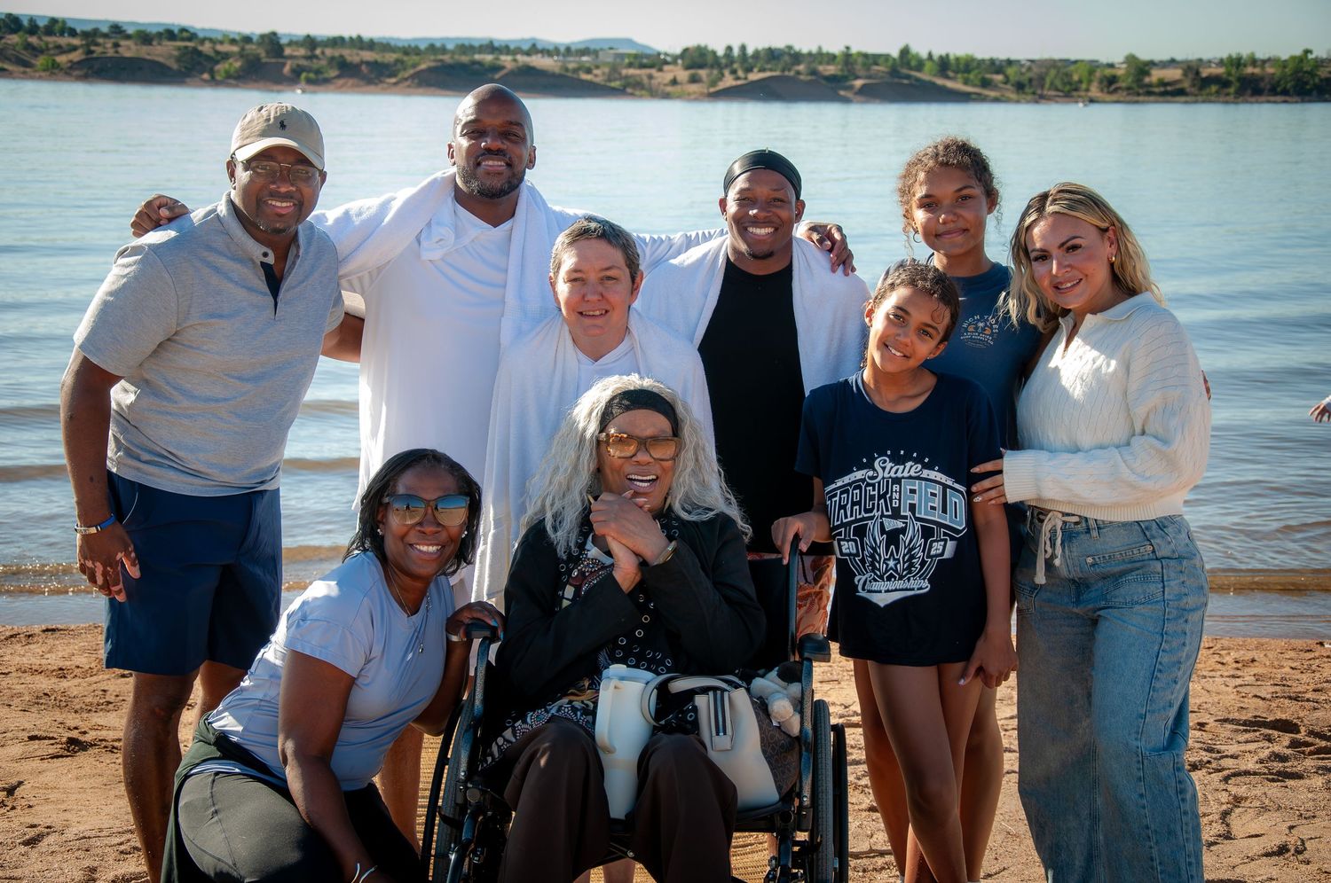 Friends share a group photo in front of a lake