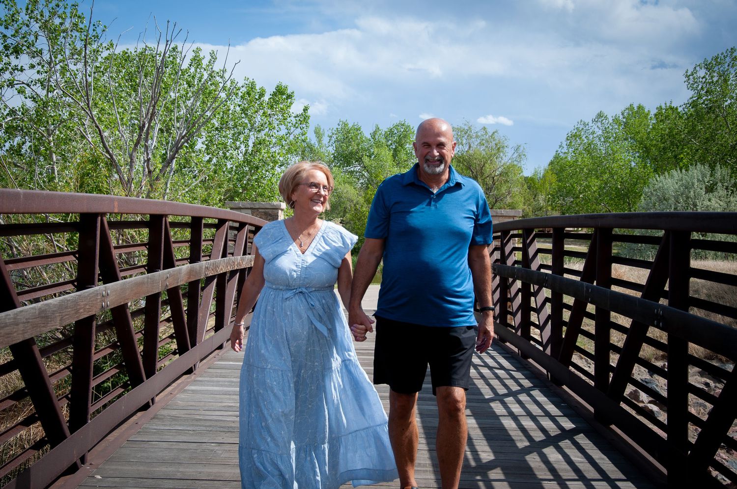 A husband and wife walk across a bridge