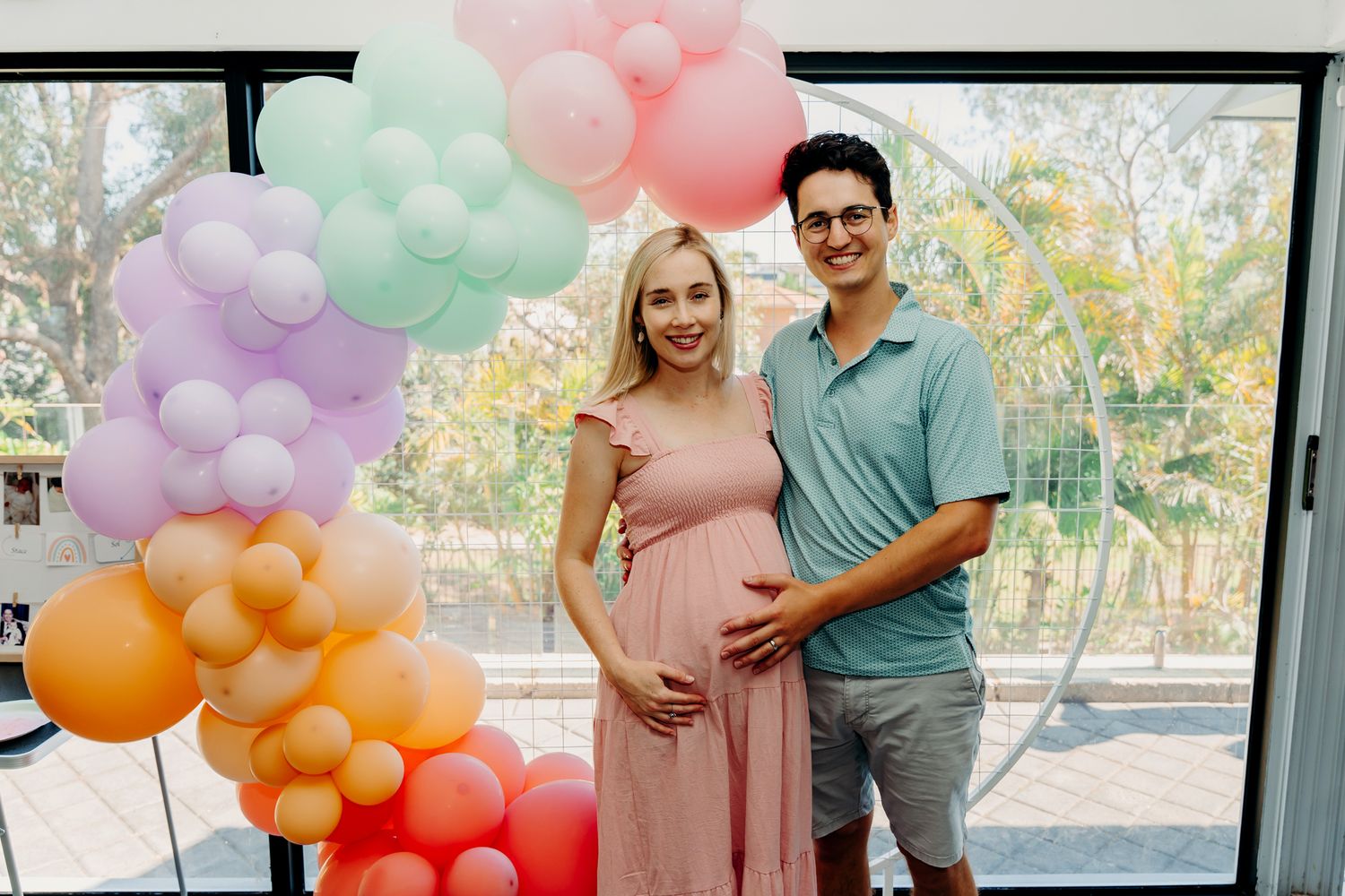 Pastel balloon arch decorates indoor celebration space.