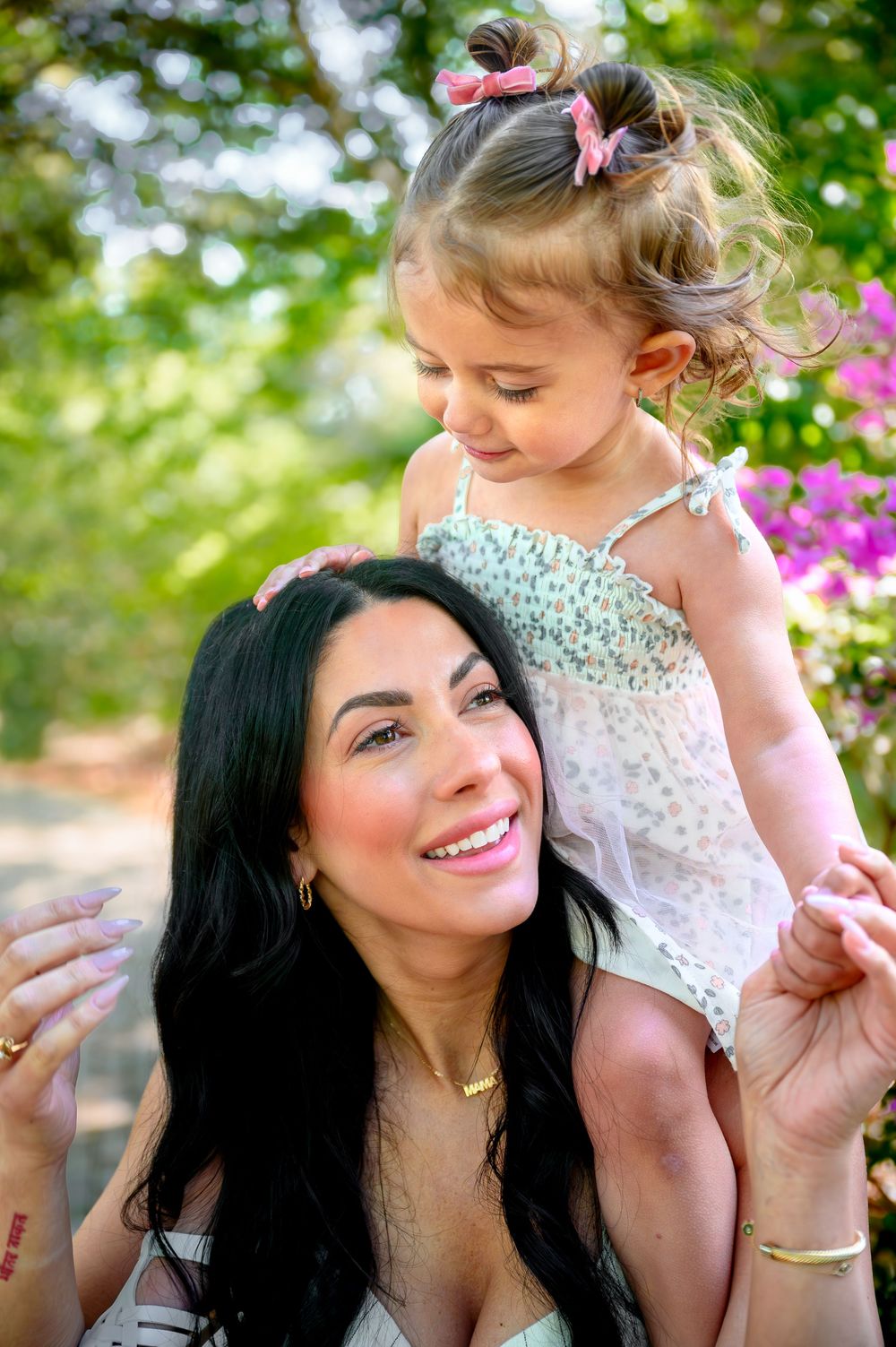 Mother and daughter sharing joyful moment together among blooming spring flowers.