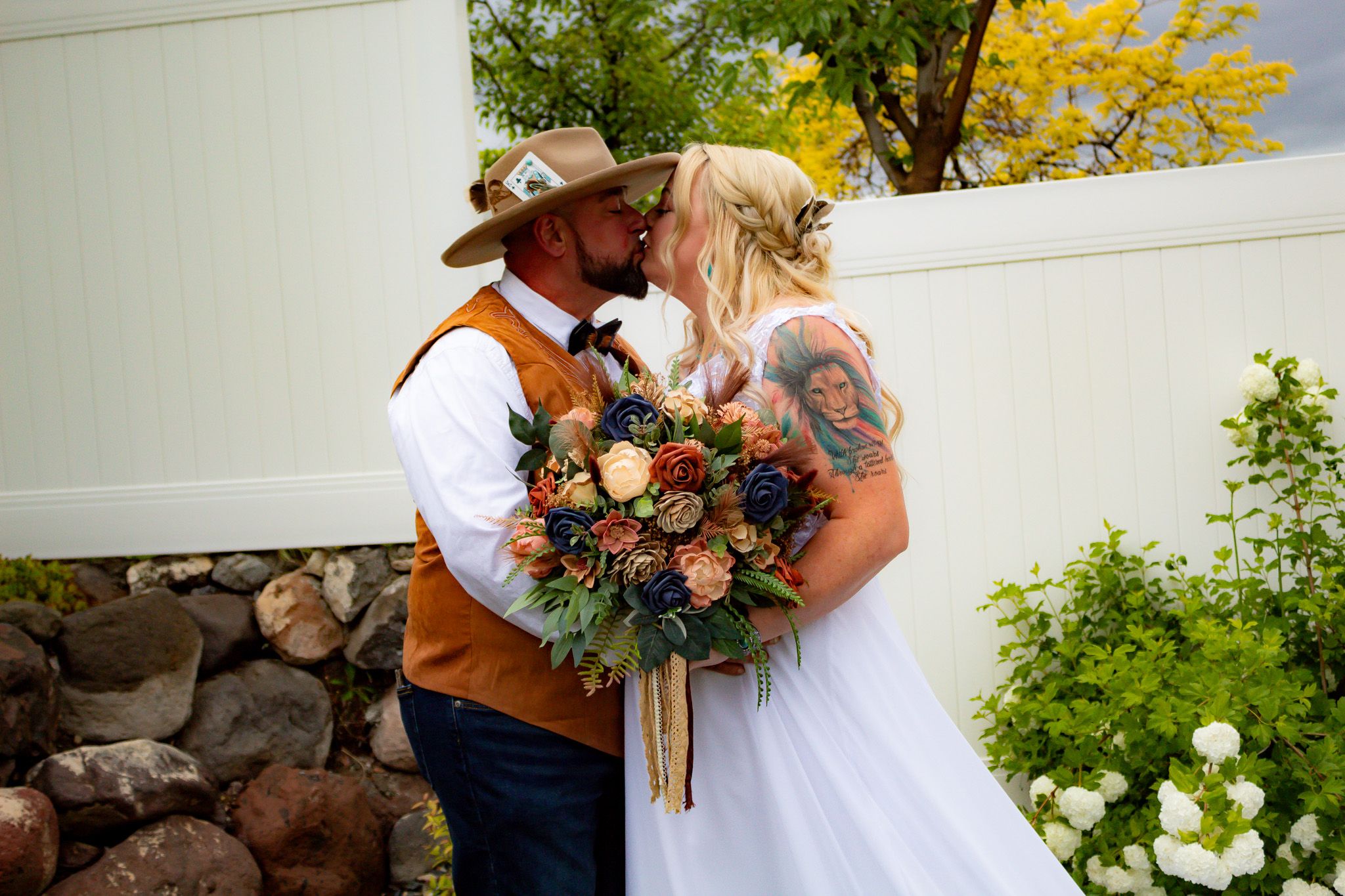 Couple shares intimate moment in garden with colorful fall bouquet.