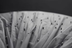 Close-up detail of delicate white fabric pleating and texture.