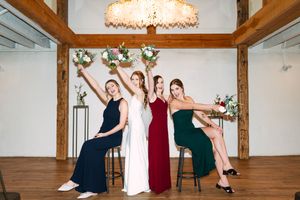 Wedding party dancing and celebrating in a rustic wooden beam venue with warm lighting.