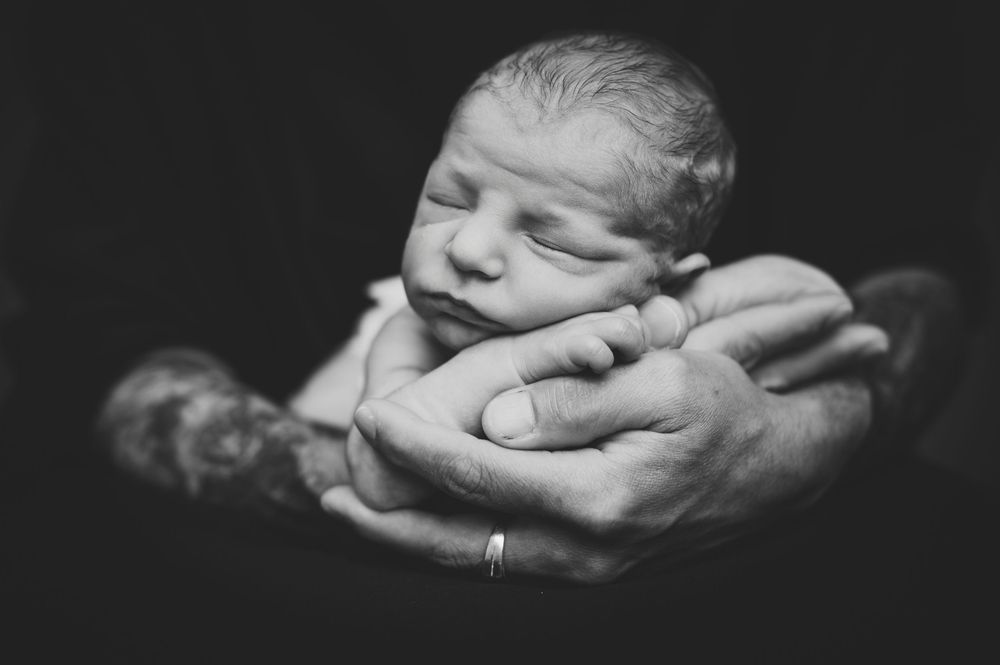 Black and white artistic photo series showing hands cradling and covering faces in dramatic lighting.