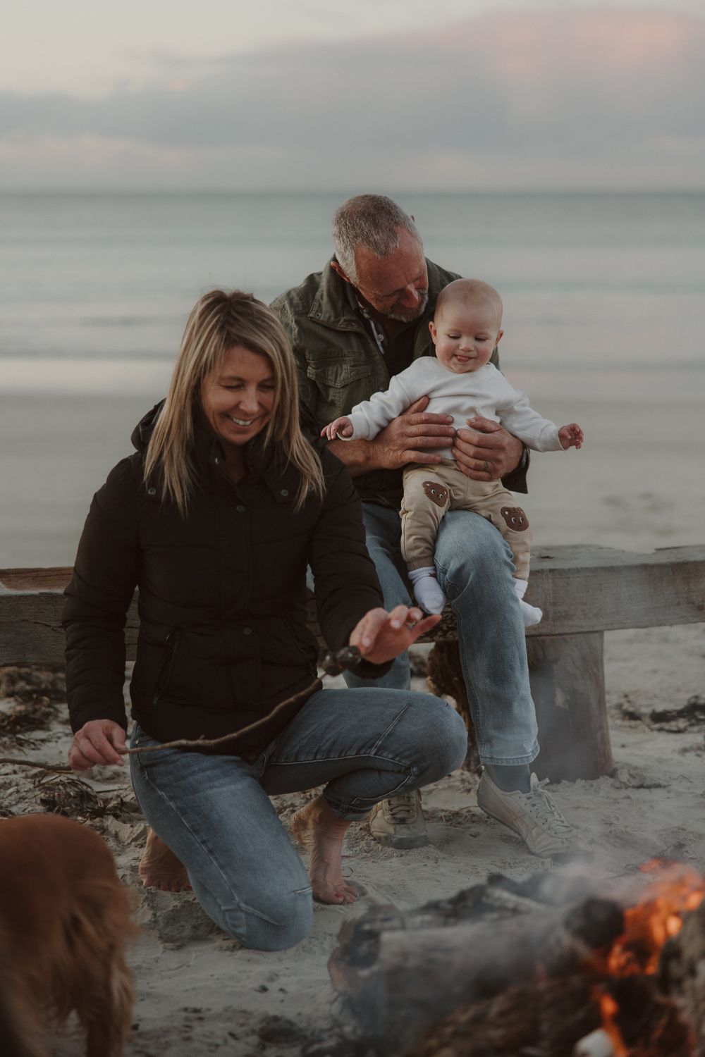 Group enjoying a cozy evening around a beach bonfire.