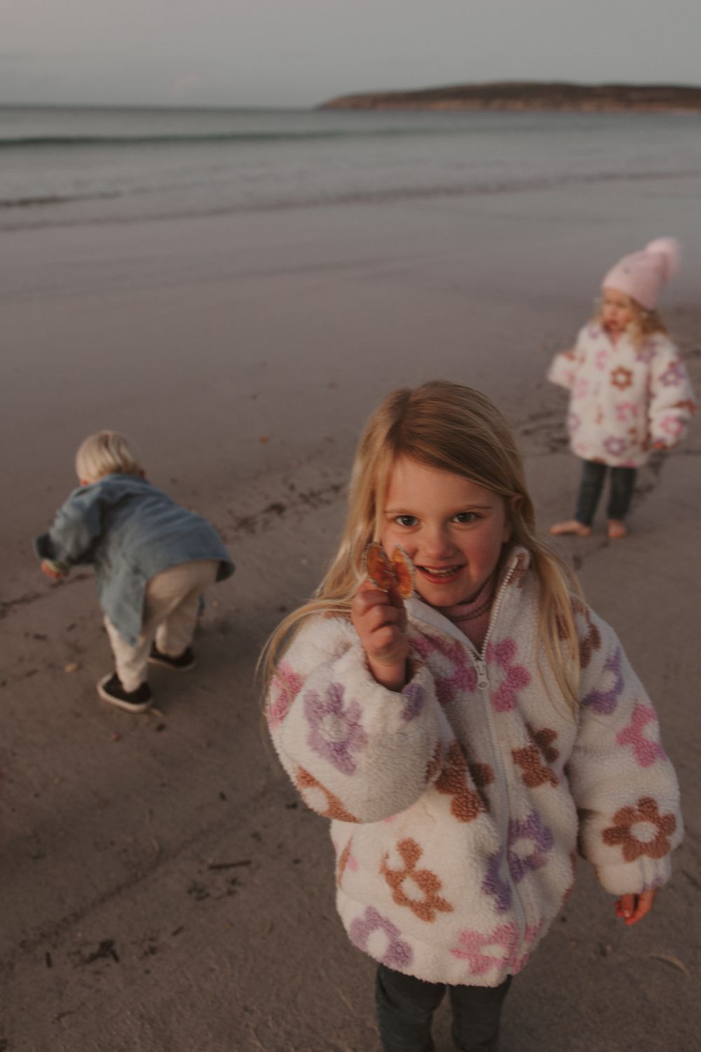 Children playing and having fun on the beach at dusk.