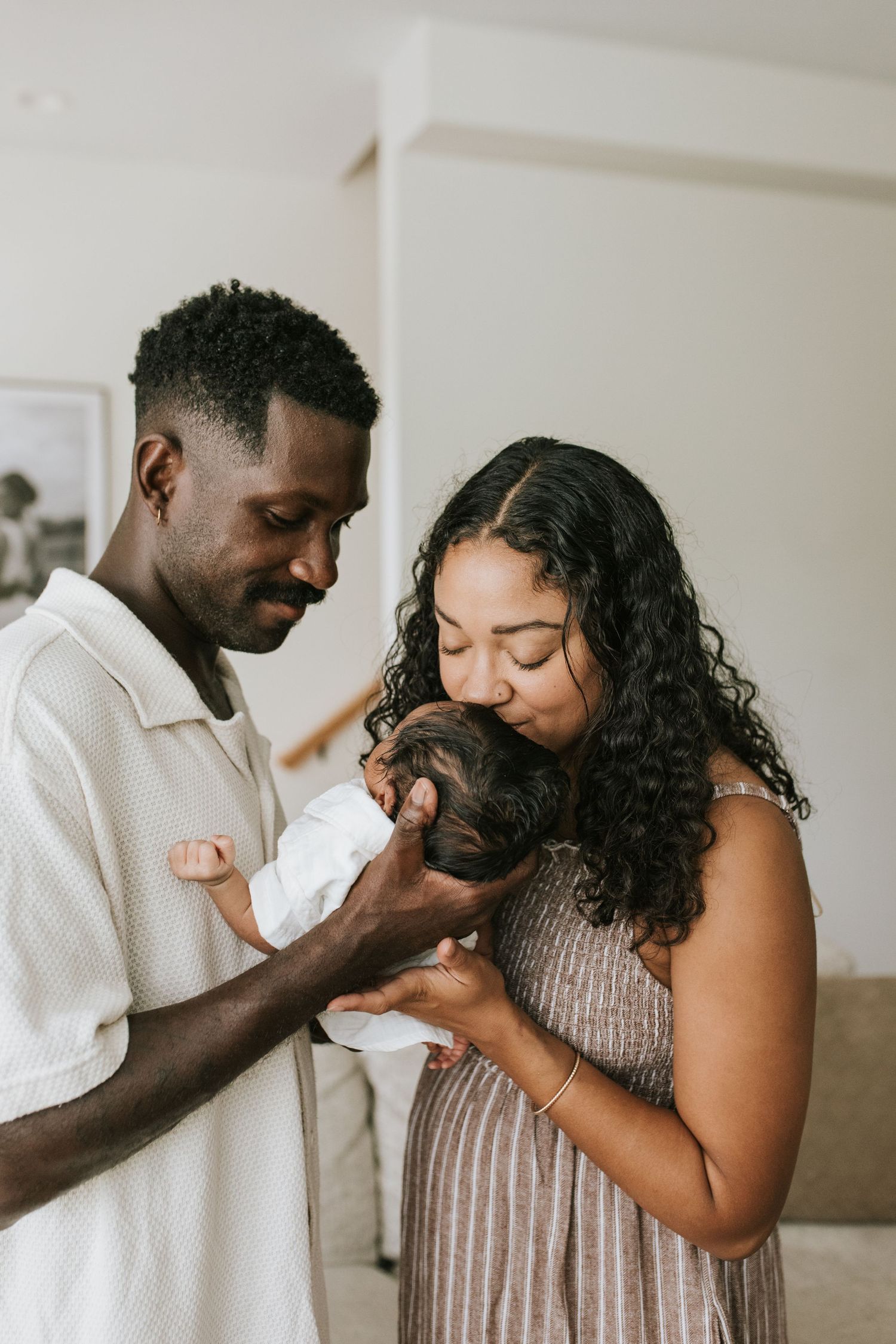 Couple sharing intimate gestures and tender moments in minimalist indoor setting.