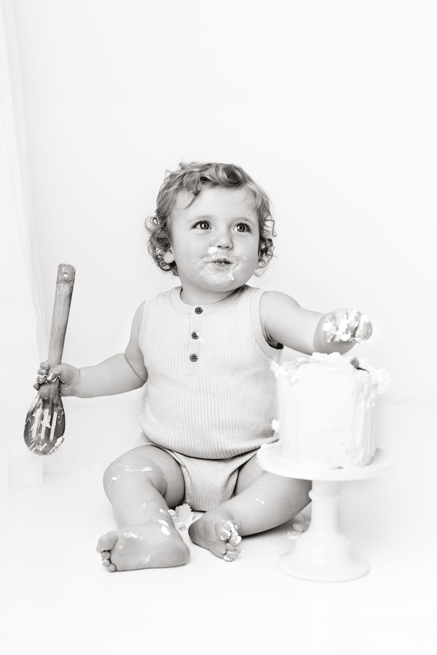 one year old gets ready to dig into his first birthday cake