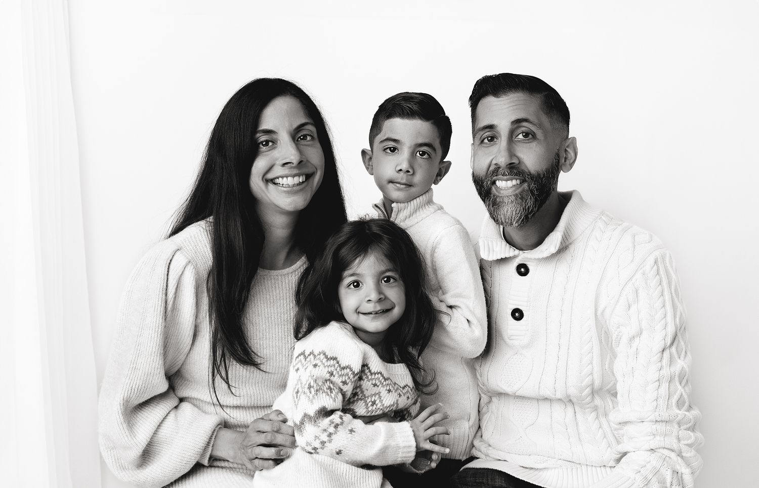 family portrait session with mom, dad, son and daughter. All wearing cozy sweaters for Christmas photos