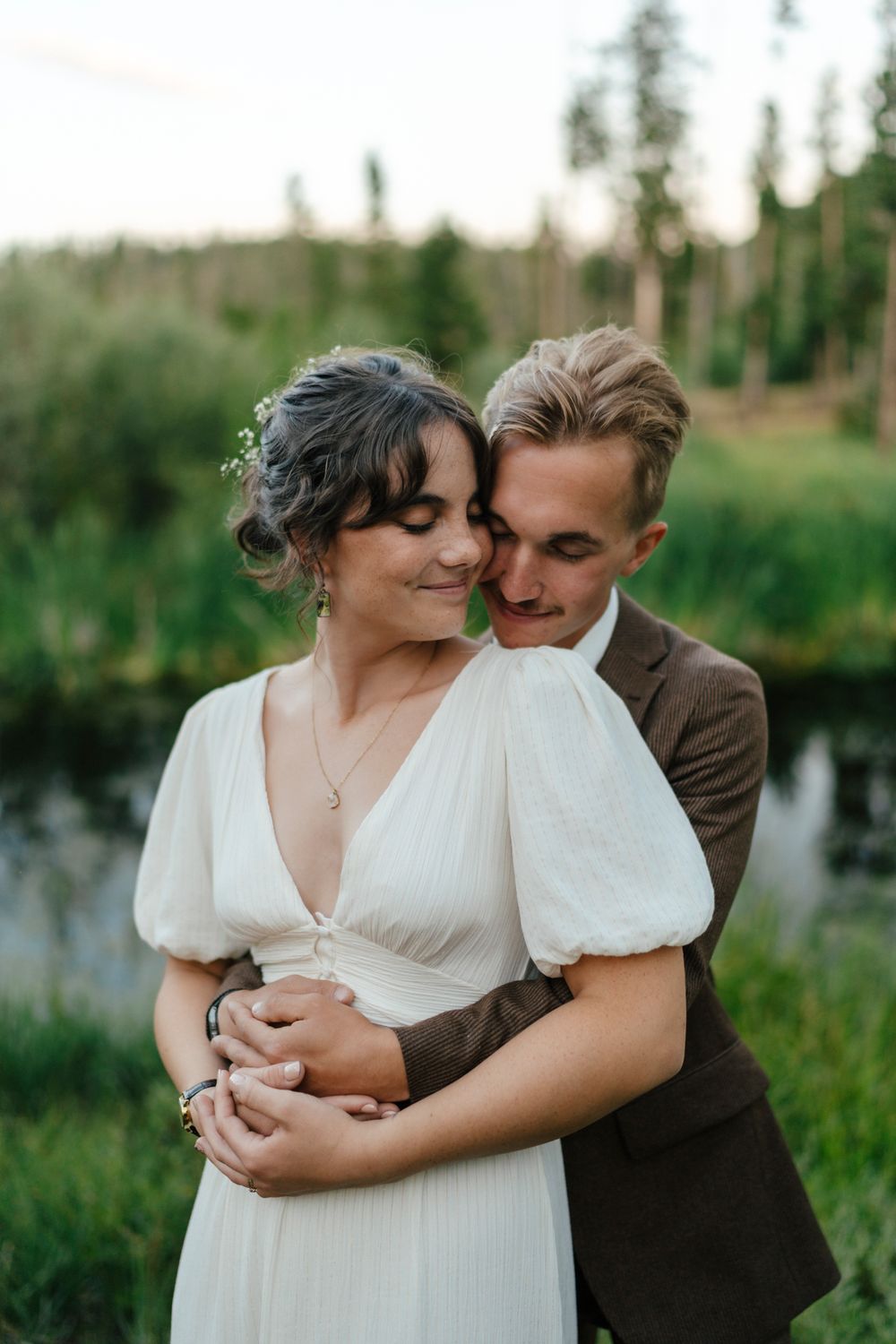 A tender embrace captured in a natural outdoor setting with soft lighting.