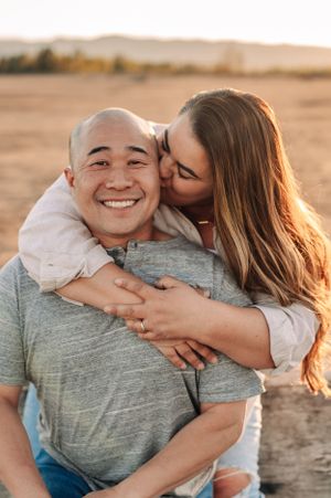 Intimate moment between couple sharing embrace on beach at sunset.