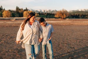 Two people walking together and laughing in an autumn desert landscape.