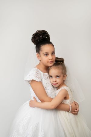 Siblings hugging and smiling for a family portrait, celebrating their bond and childhood.