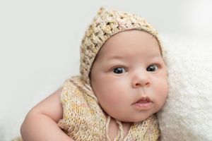 “Newborn baby sleeping peacefully in a soft blanket during a studio session.
