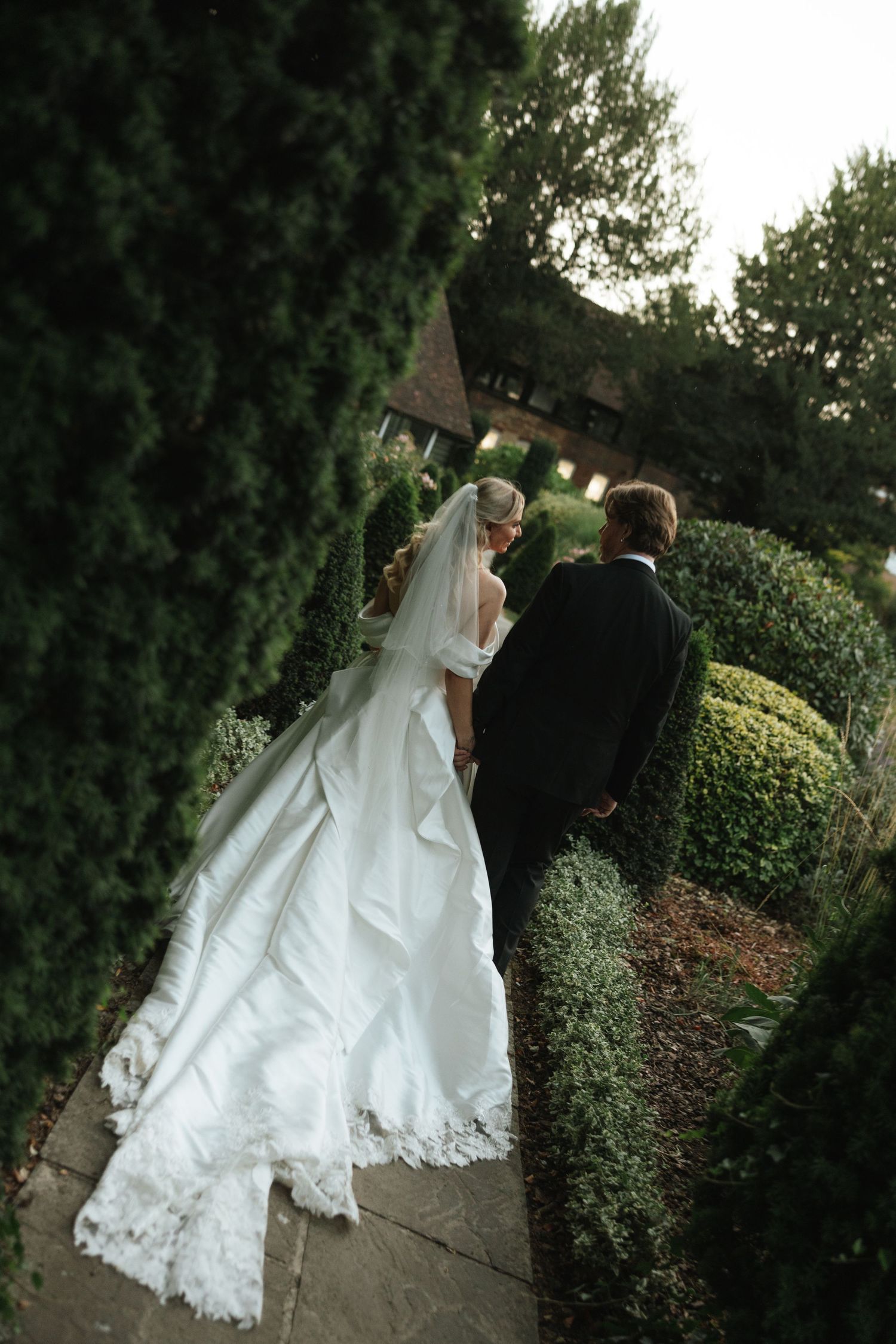 Elegant white wedding reception venue with chandeliers and table settings.