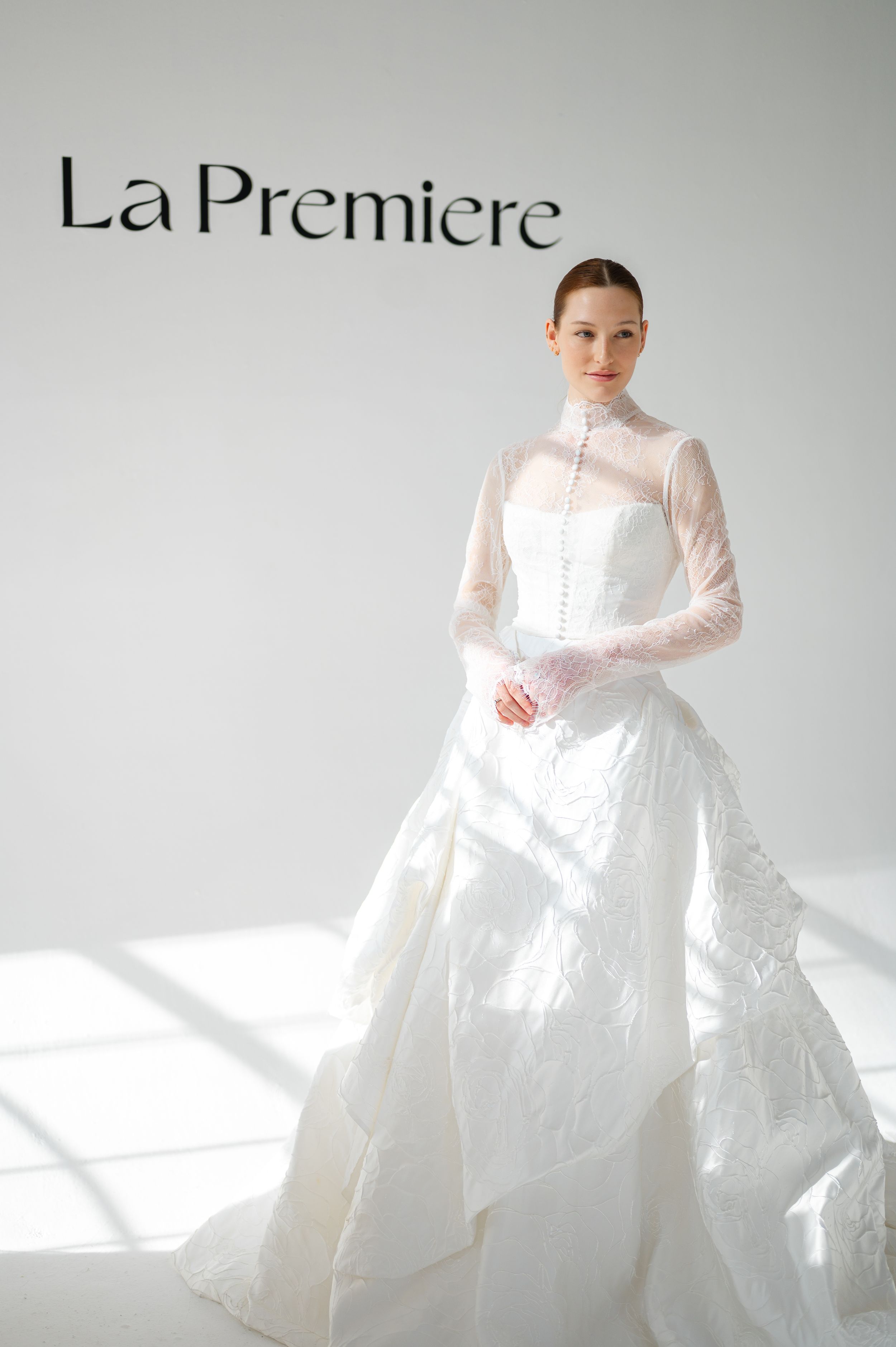 Elegant bridal gown with high neck sheer overlay, structured bodice and dramatic full skirt in pristine white.