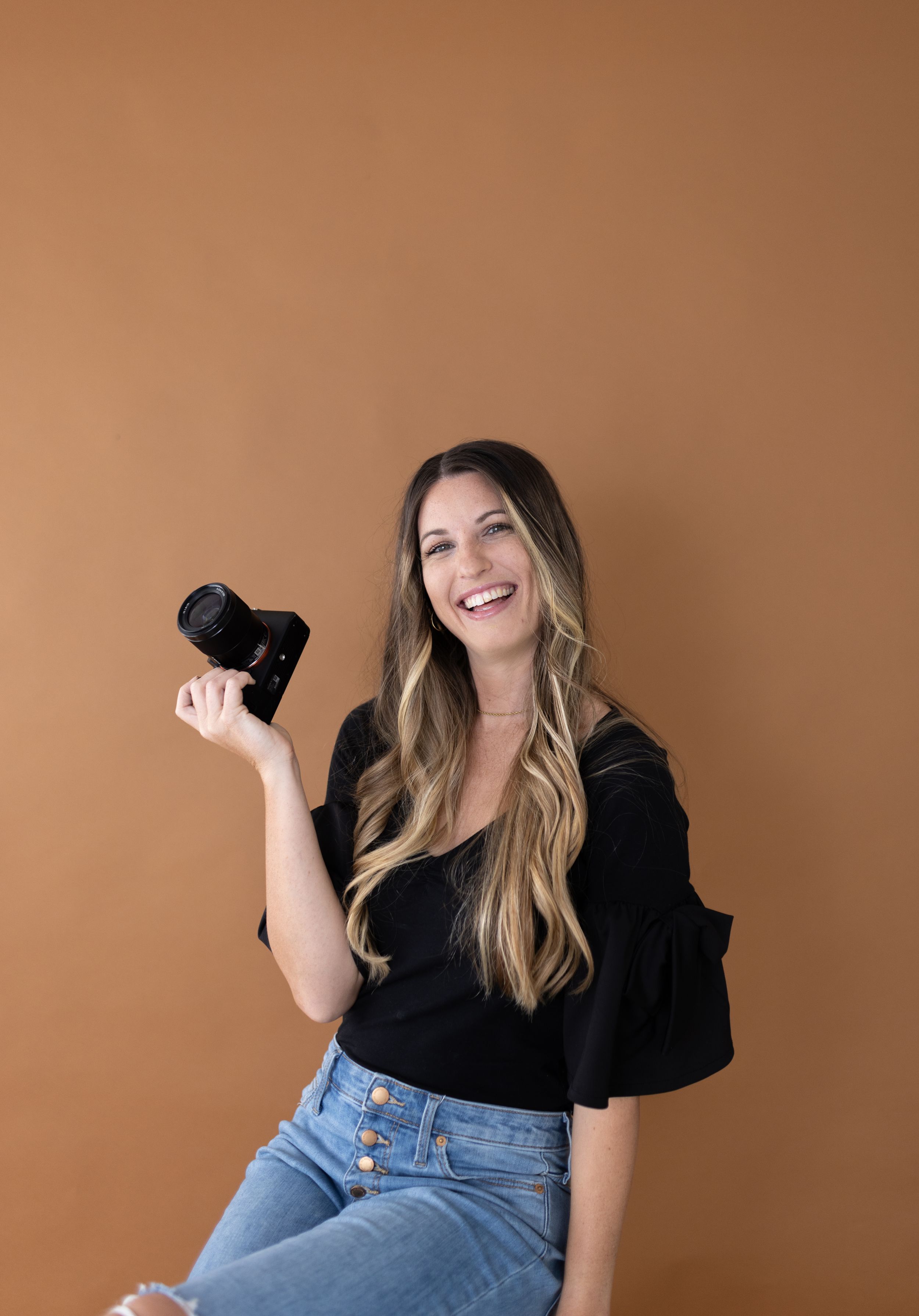Orlando luxury wedding photographer introduces herself with camera.