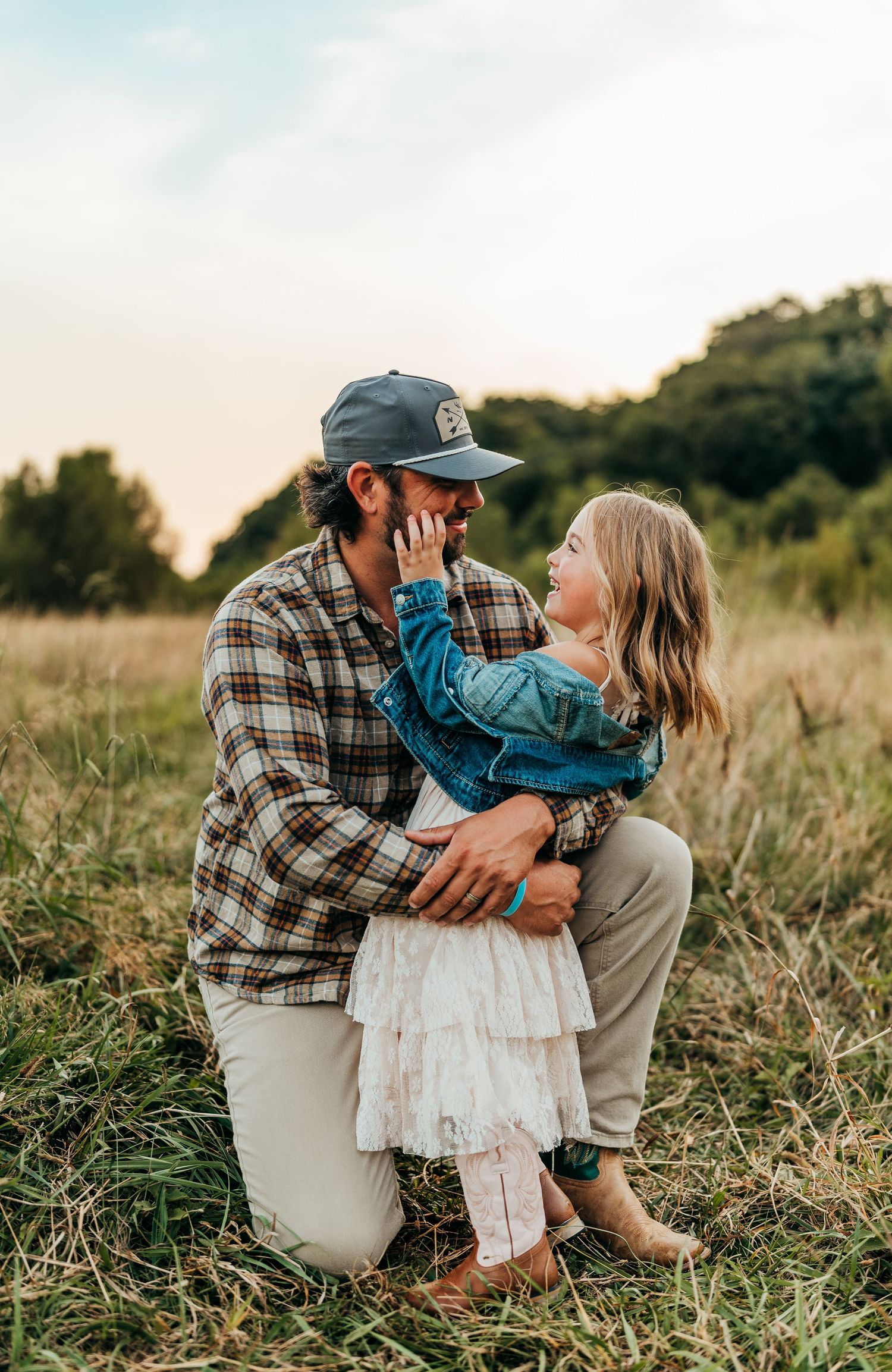 Tender family moment captured in rustic field setting during golden hour family photographer rockford il
