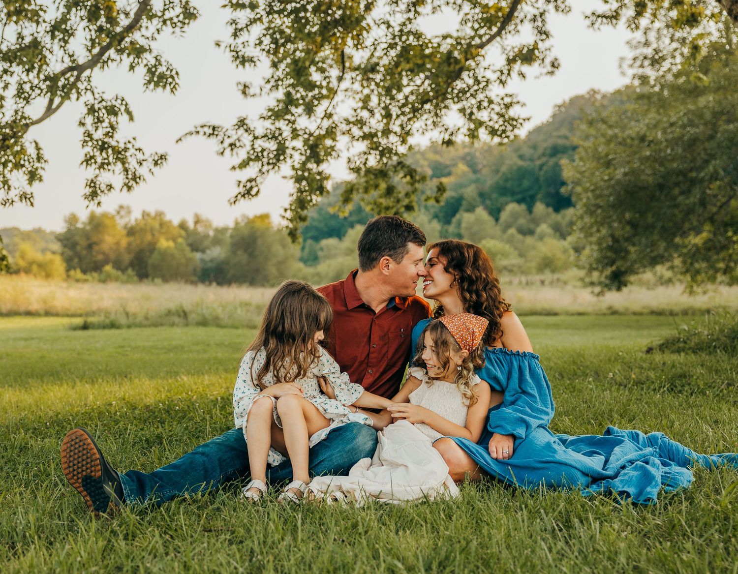 Family relaxing together on a picnic blanket in a sunlit meadow during golden hour roscoe il