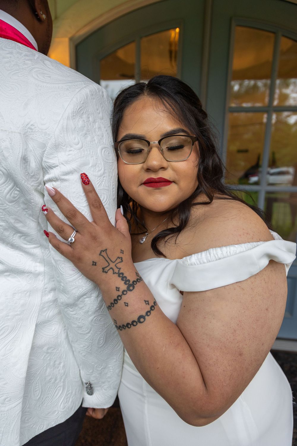 bride embracing husband, rings visible