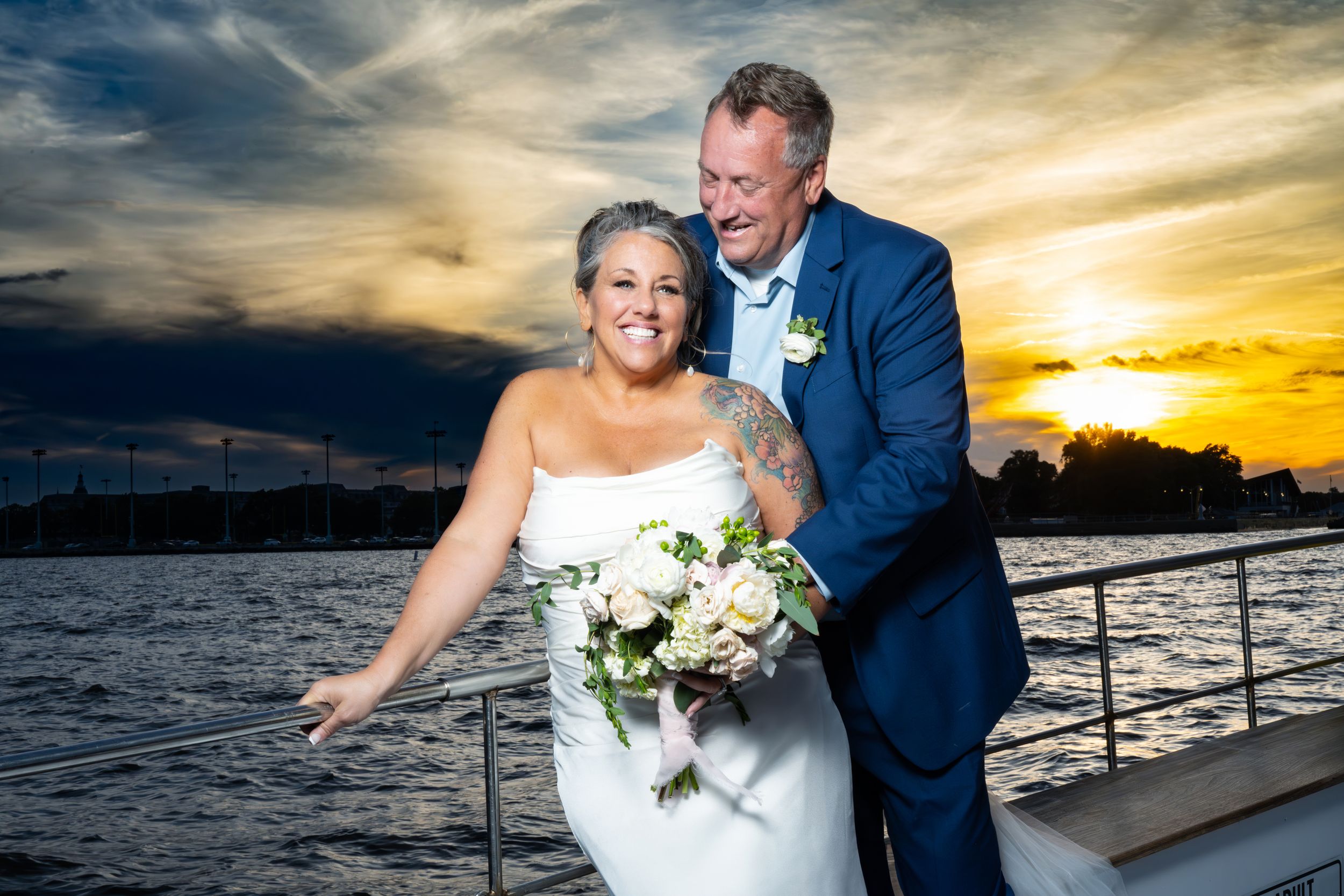 Romantic wedding photo of couple on a boat during golden sunset.