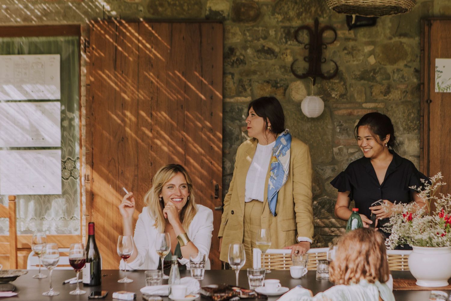 Guests enjoying conversation at a rustic indoor-outdoor wedding reception venue.