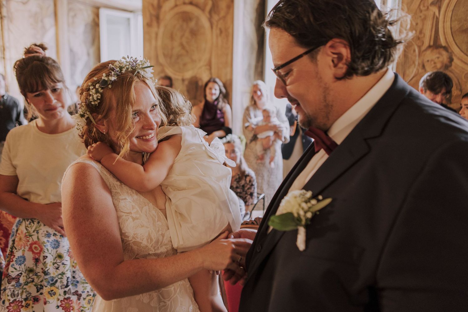 A sweet moment shared during wedding festivities in an ornately decorated venue.
