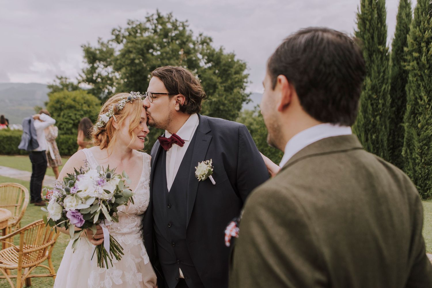 Newlyweds share an intimate moment outdoors during their wedding celebration.