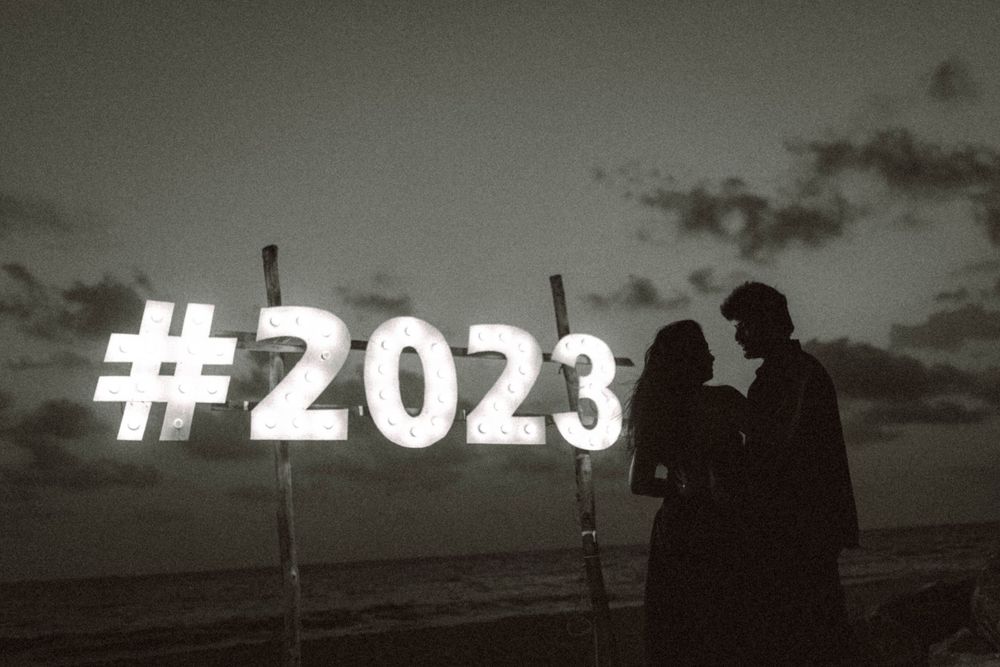 Silhouettes against a dramatic sunset sky with text overlay reading #2023.