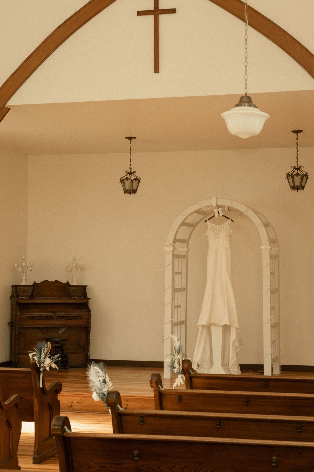 A simple church sanctuary with wooden pews and arched ceiling featuring classic architectural details.