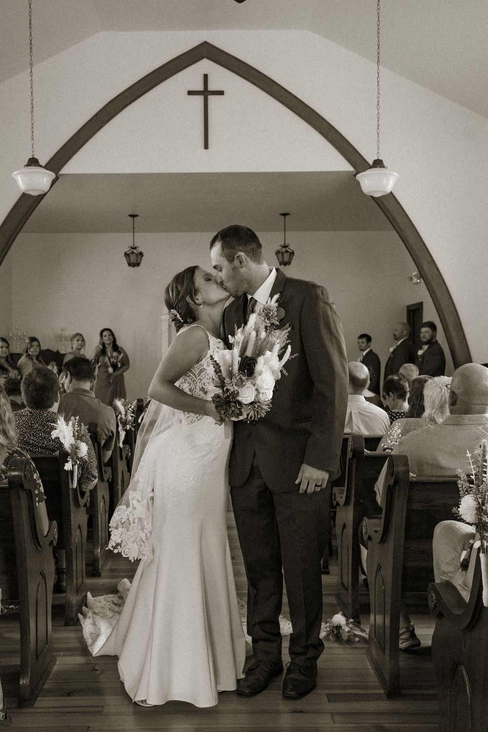 Wedding reception dance in a church hall with arched ceilings and romantic lighting.