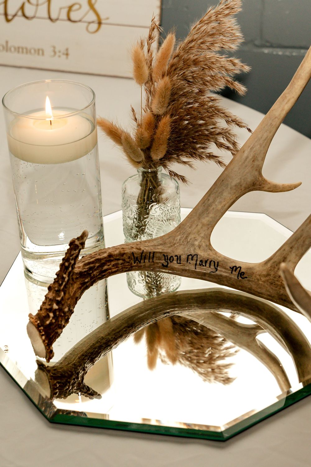 Rustic wedding centerpiece with dried flowers, candles and mirror base.