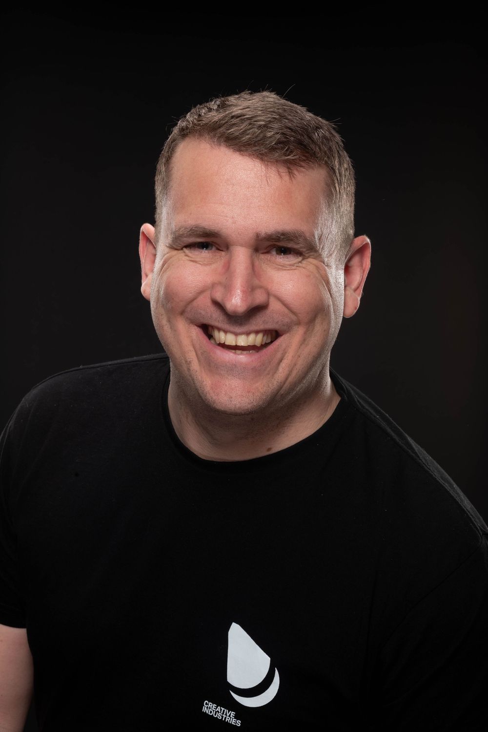 A sequence of black and white portrait photos showing a smiling expression against a dark background.
