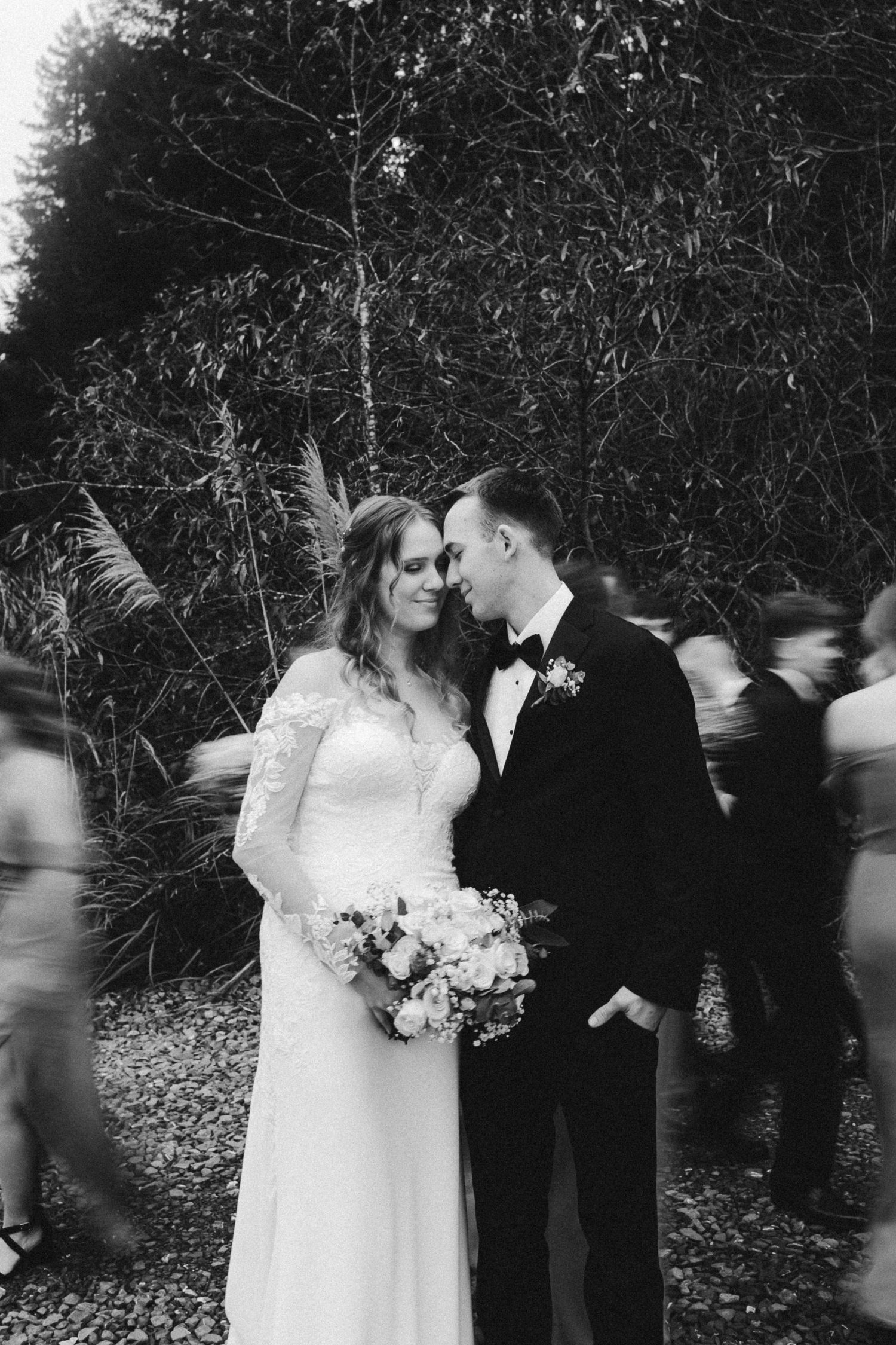 Taylor Carpenter Photography Captures black &  white photo of bride and groom being surrounded by bridal party in Crescent City, California
